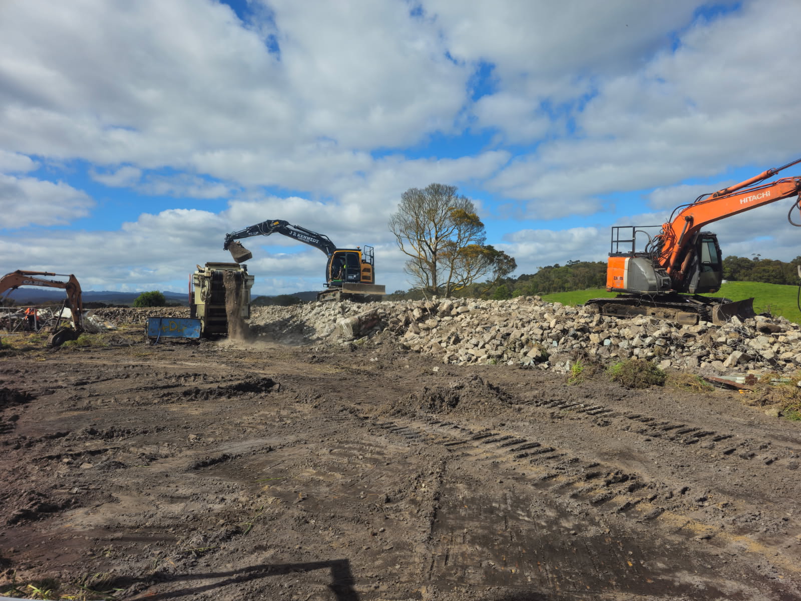 Excavators feeding a mobile crusher, recycling concrete on site